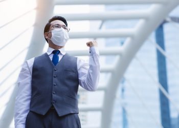Businessman wear medical face mask Handsome man get confident and determined of business. Gentlemen asian guy get successful of business and celebrate of winning of his goal with city background