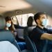 Handsome man driving a car and working as a rideshare driver during the coronavirus pandemic