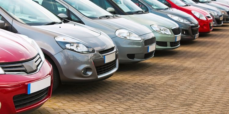 Line up of various types of used cars for sale on a motor dealers forecourt all marques removed