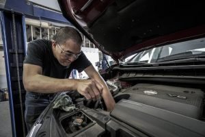 A picture of a mechanic fixing a car with a vehicle protection plan from Red Shield Administration