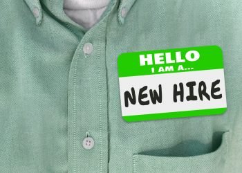 New Hire nametag on a green shirt worn by a new employee or fresh talent just brought onboard to a company or business