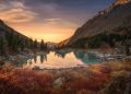 Pink Sky And Mirror Like Lake On Sunset With Red Color Growth On Foreground, Altai Mountains Highland Nature Autumn Landscape Photo. Beautiful Russian Wilderness Scenery Image.