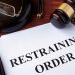 Restraining order and gavel on a table.