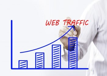 Businessman hand writing Web Traffic graph  with red marker on transparent wipe board, business concept.