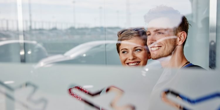 Portrait of smiling couple at the airport looking out of window