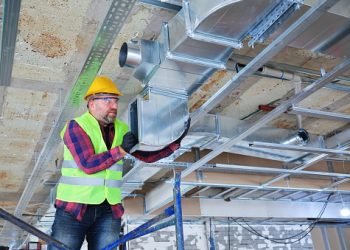 Manual Worker  installing air conditioner in building.