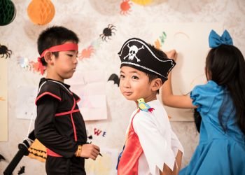 Halloween day, children wearing costumes playing in the room.